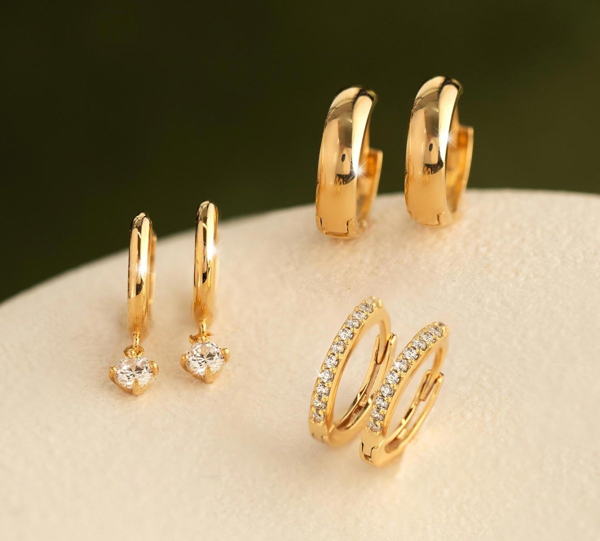 Elegant collection of AMYO Jewelry’s solid 14K gold huggie earrings including pavé and gemstone styles