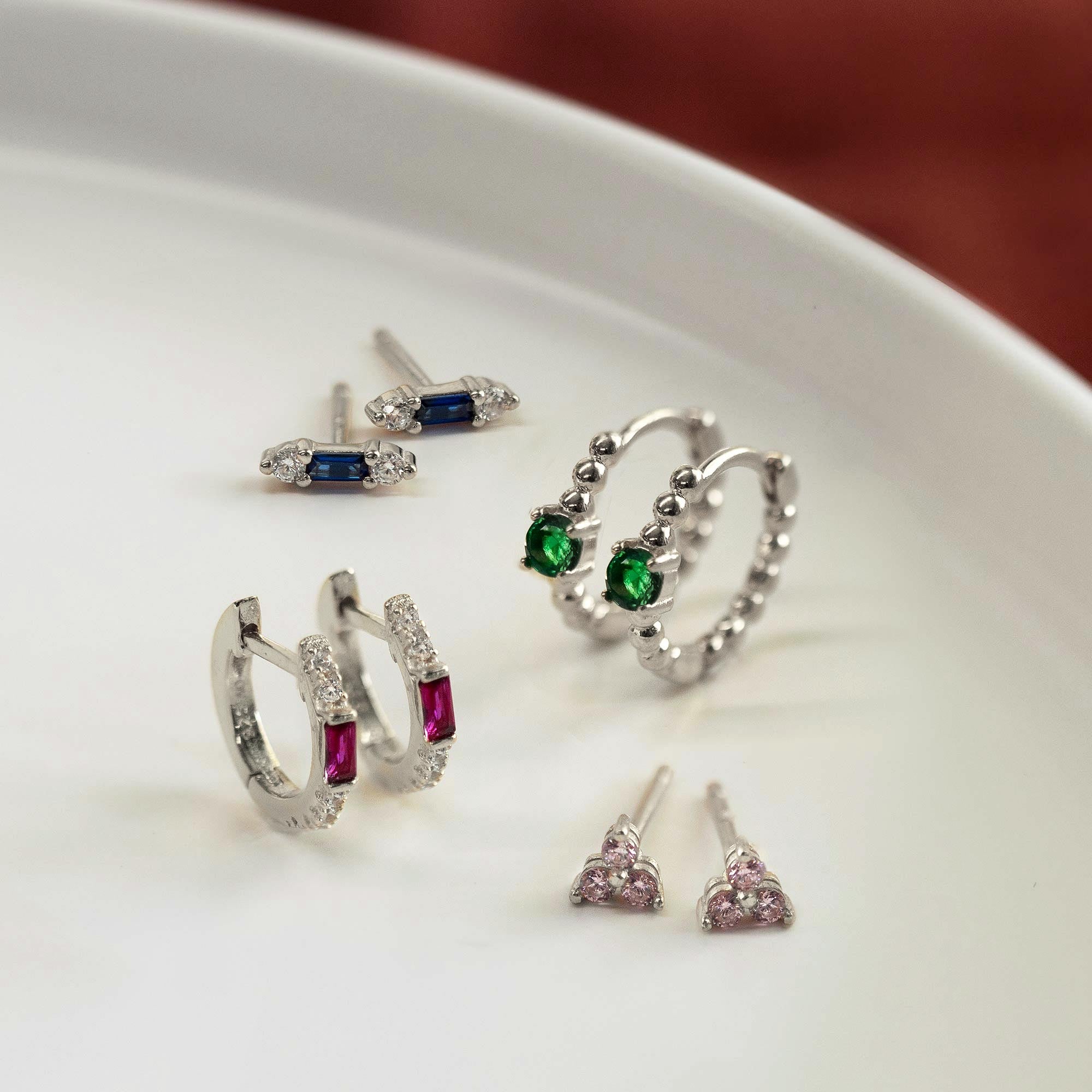 Close-up on earring featuring Sterlign Silver Gemstone Bead Huggies Emerald CZ Crystal and other gemstone earrings.