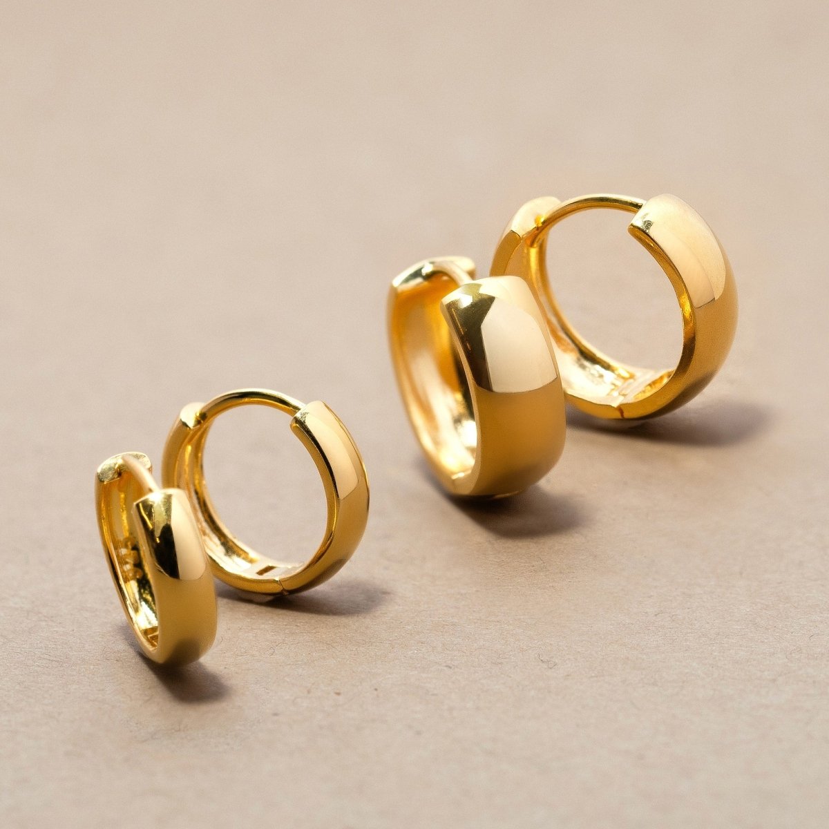 Displaying the tiny and big gold vermeil boyfriends huggie earrings.