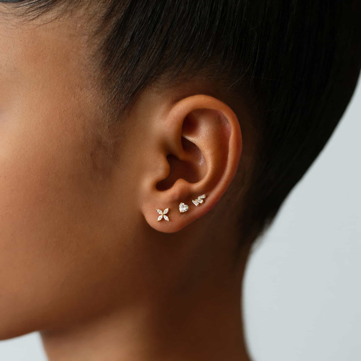Gold vermeil crystal flower stud shown in a stack on a model's earlobe