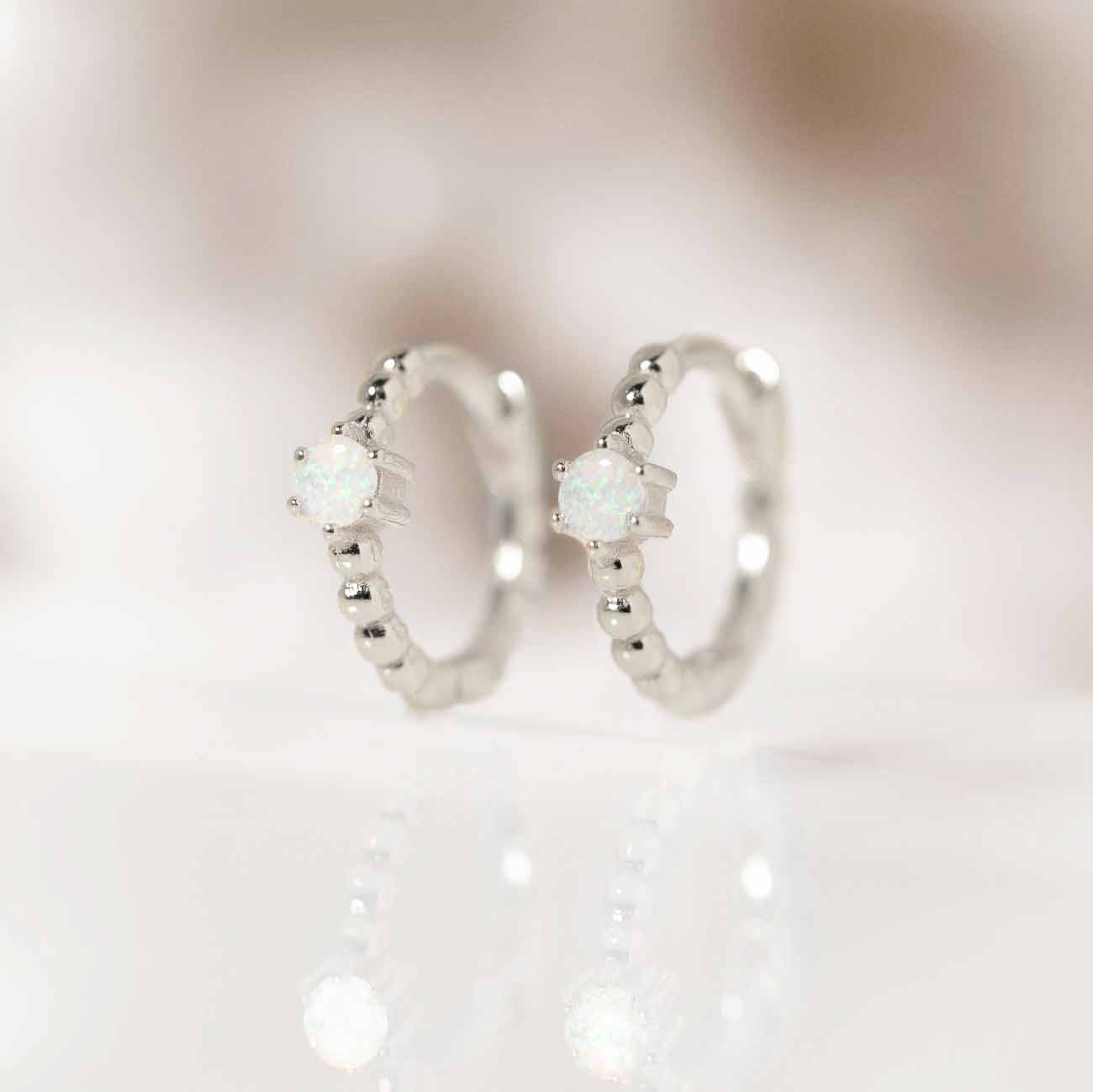 Close-up of earring featuring Sterling Silver Gemstone Bead Huggies Opal.