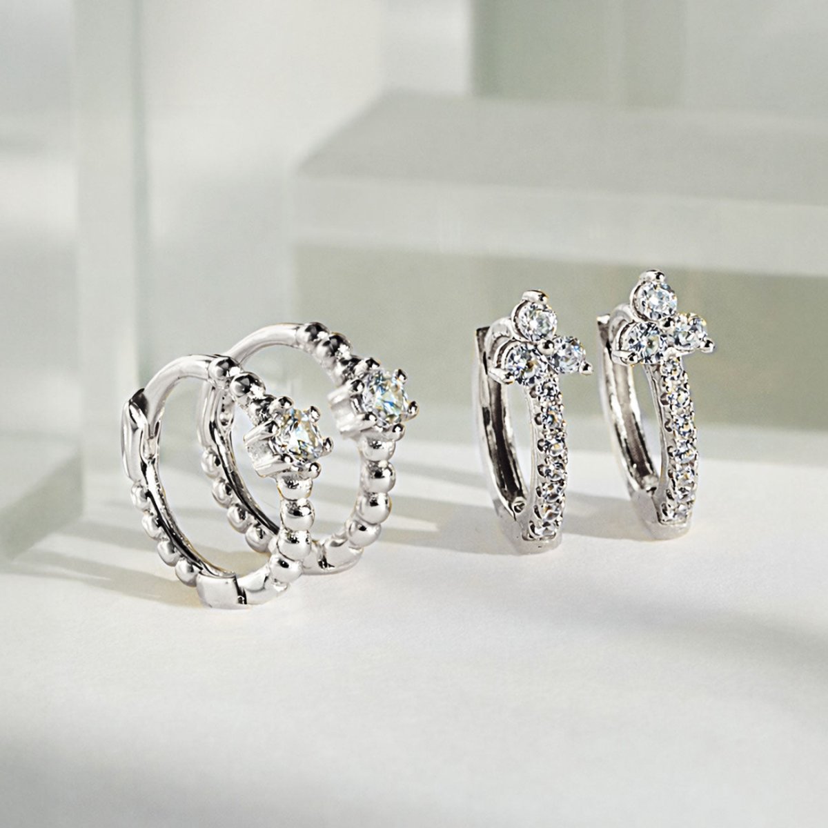 AMYO sterling silver huggie earrings with cz accents, featuring textured and pavé designs, styled as timeless everyday earrings perfect for gifting.