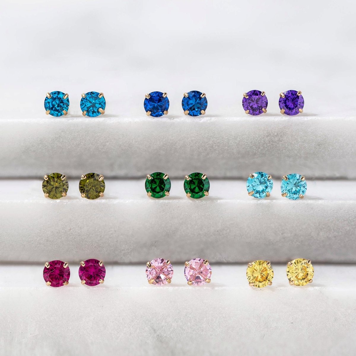 Close-up of earrings featuring 14K Gold Birthstone Tiny Studs