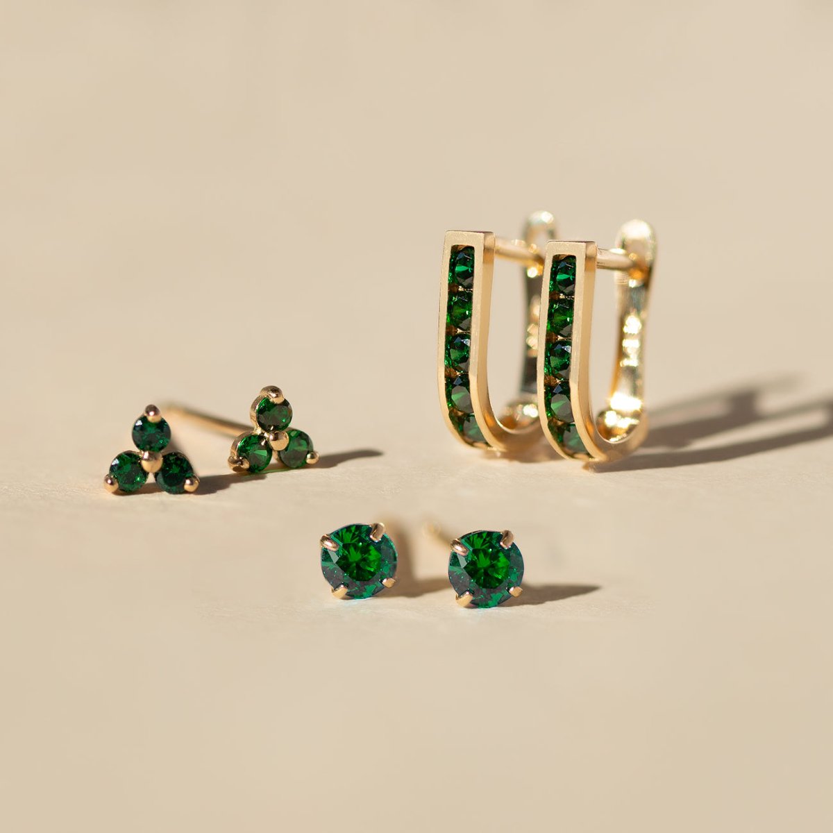 Close up of earring featuring 14K Gold Gemstone Emerald CZ Crystal stud and hoop collection