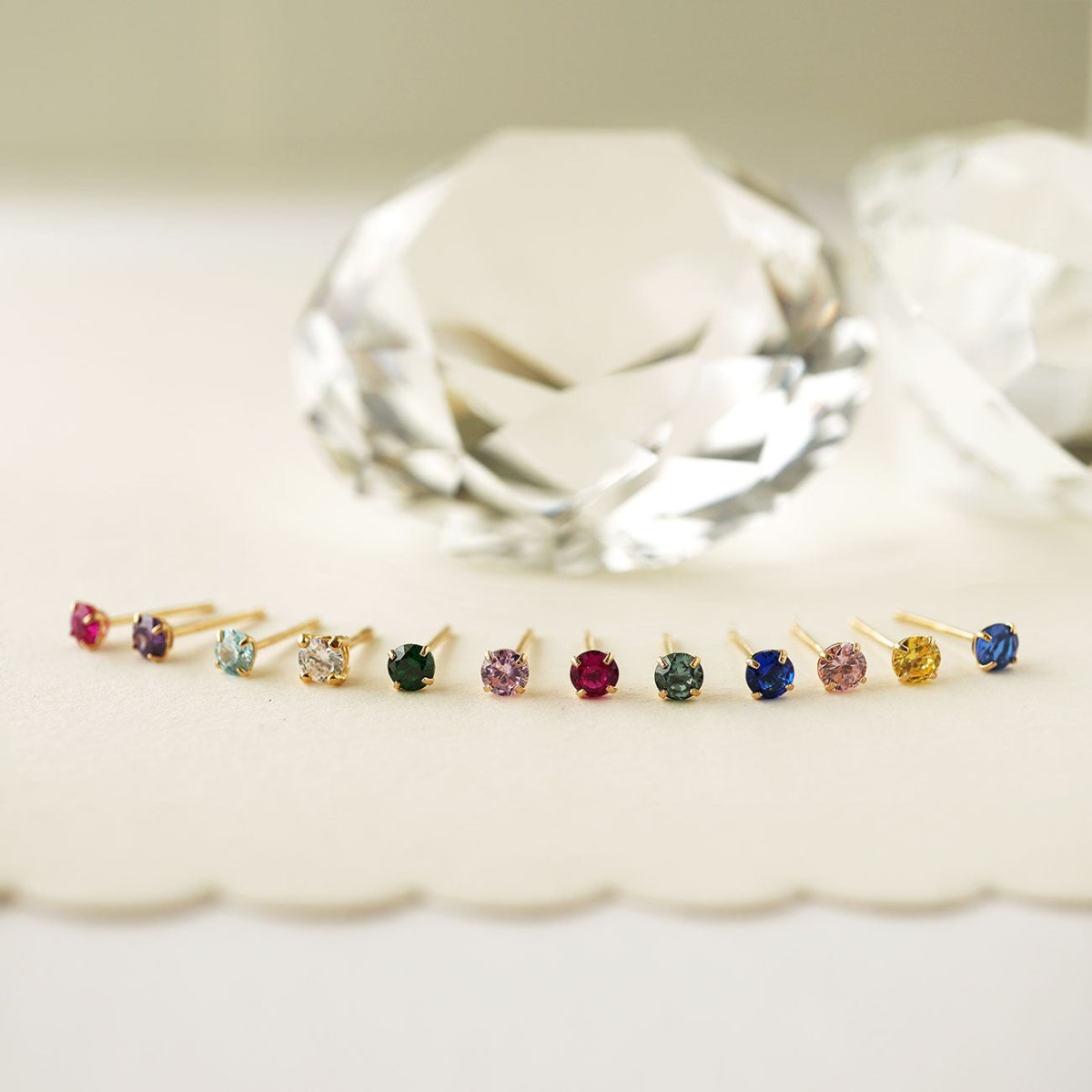 Close-up of earrings featuring 14K Gold Birthstone Tiny Studs