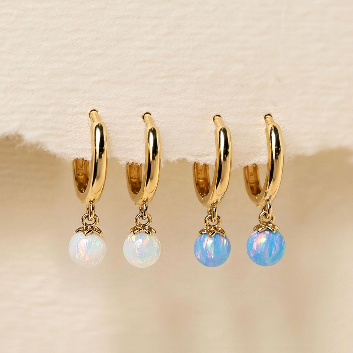 Dangling 14K Gold Tiny Opal Huggies with Blue Opal and White Opal from AMYO
