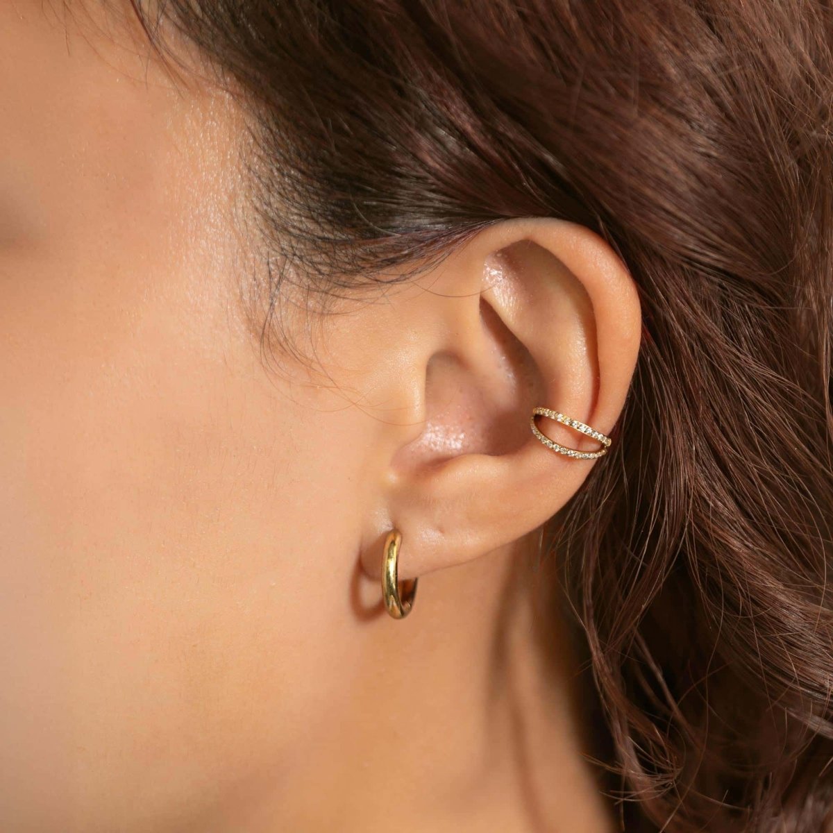 Gold titanium double pavé hoop earring with white zirconia, shown on a model's helix