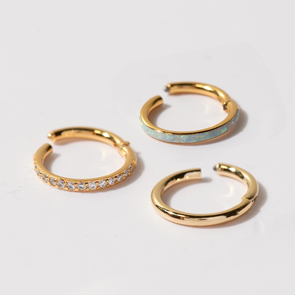 Close-up of 14k gold cartilage pave hoop earring and gold vermeil seamless clicker ring