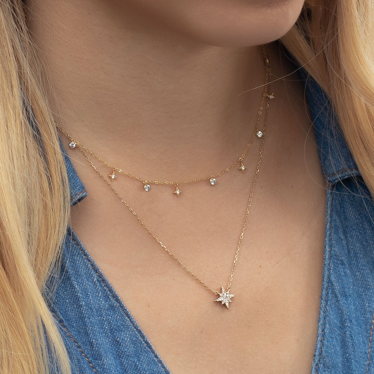 woman wearing two layered gold necklace with dangle crystals and star pendant