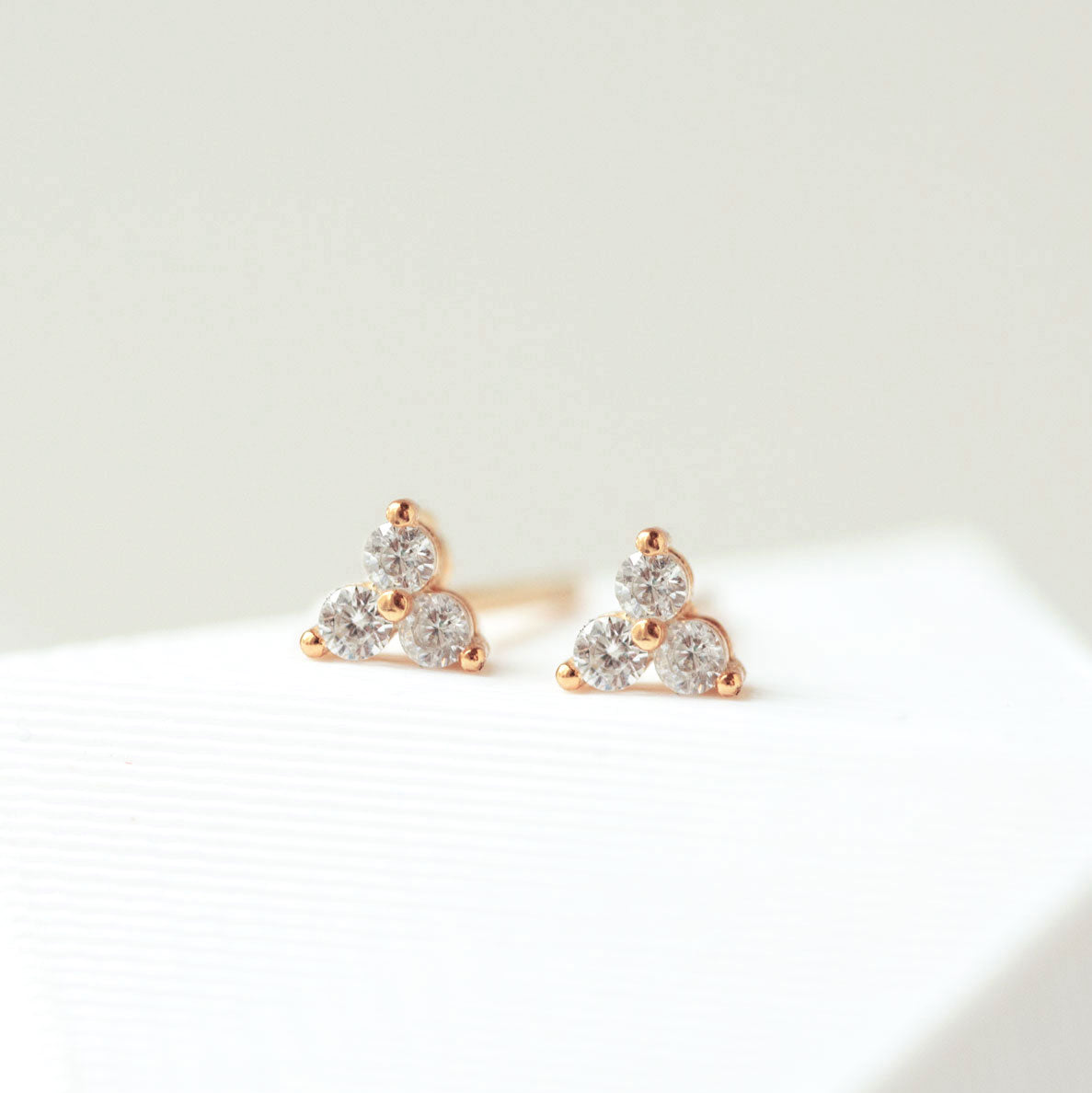 Close up of earrings featuring 14K Pave Clover Rose Gold Stud Earrings