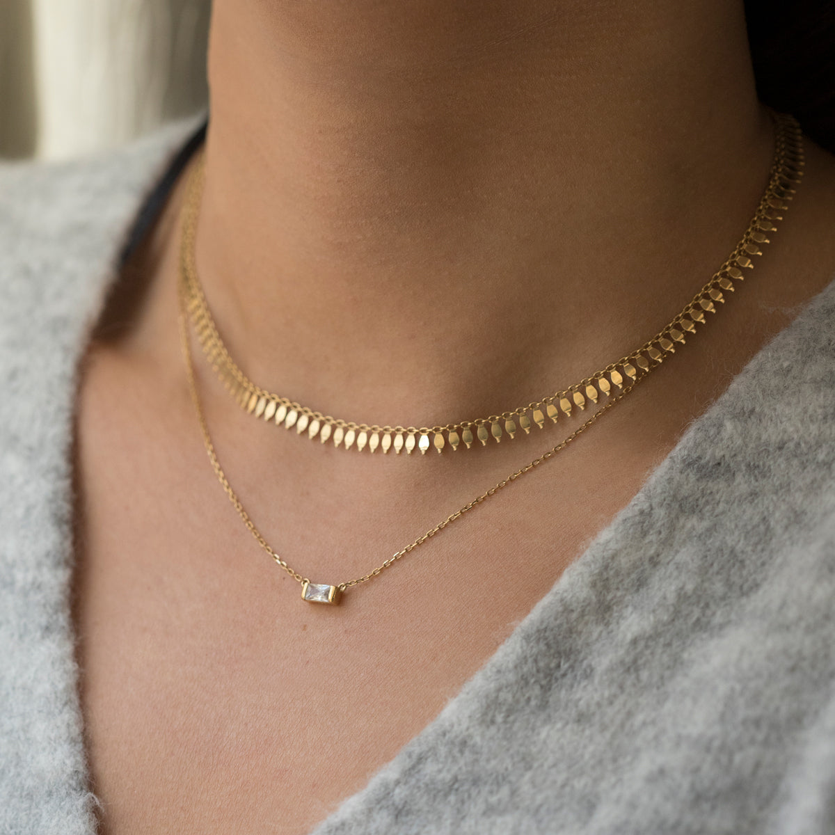 Model wearing Gold Chain Choker and Baguette Layered Necklace with sweater