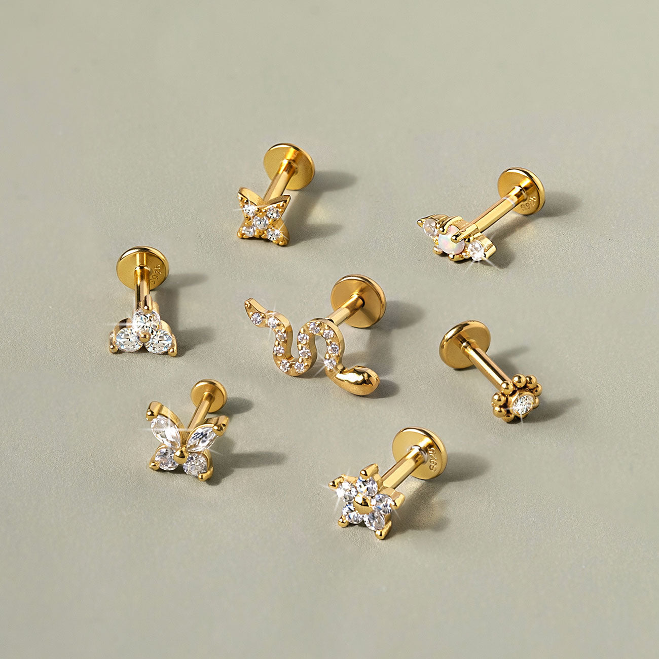 Gold vermeil and gold titanium flat back stud earrings in butterfly, star, snake, and flower designs