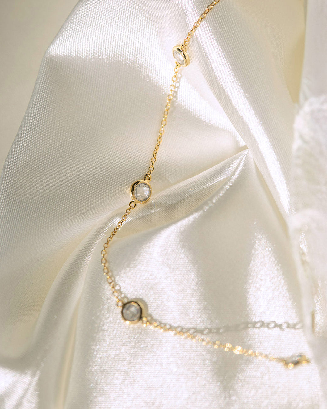 AMYO delicate gold necklace with bezel-set crystals, designed for layering and modern minimalist jewelry styling, perfect for everyday elegance.