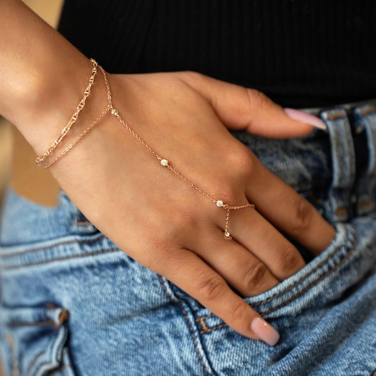 Woman wearing rose gold dainty crystal handchain and rose gold marina chain bracelet