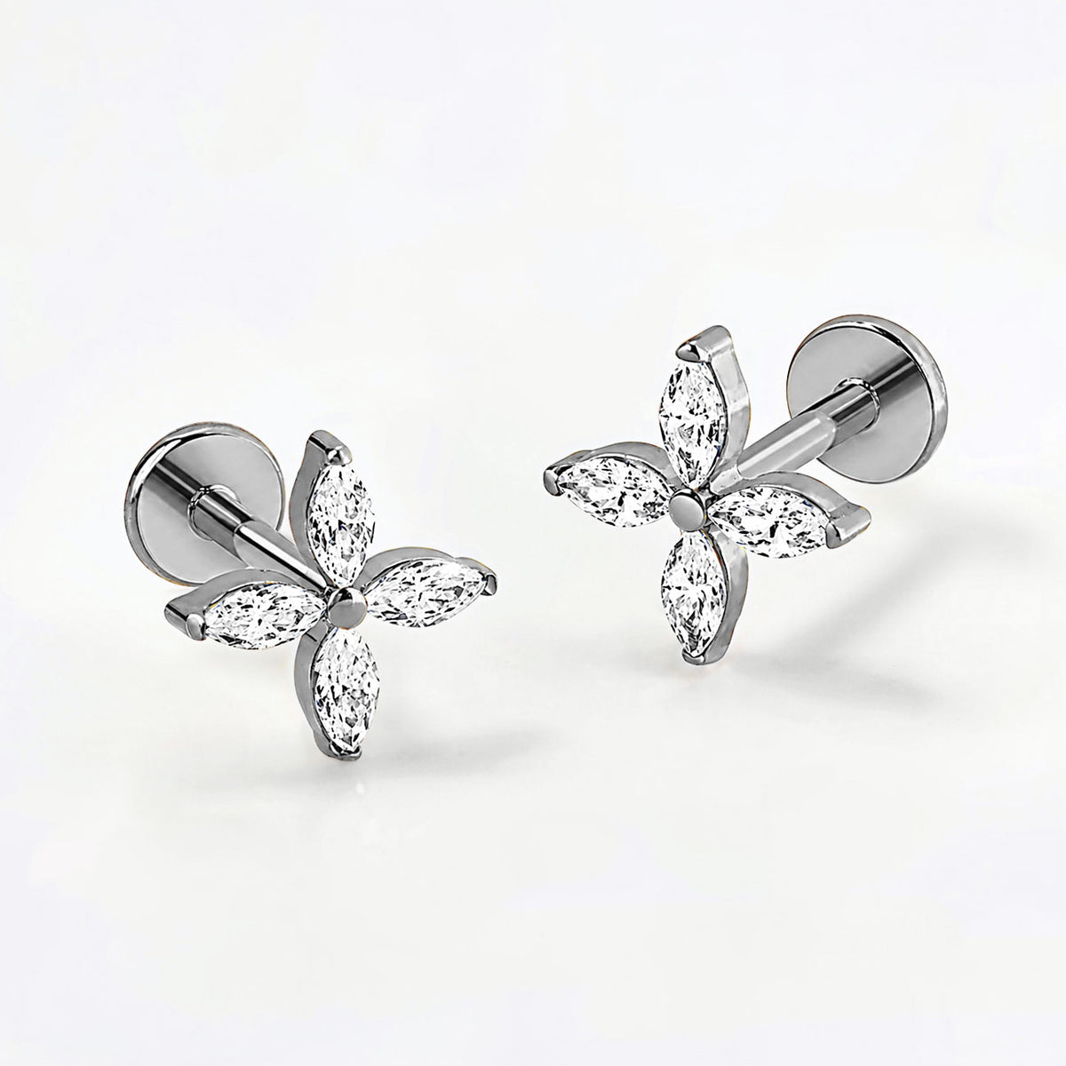 Titanium crystal fleur flat back stud earrings, on a grey background