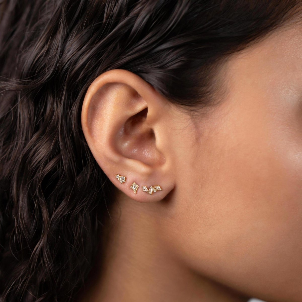 Gold vermeil tiny duo pavé studs with clear zirconia, shown in an ear stack on a model's lobe