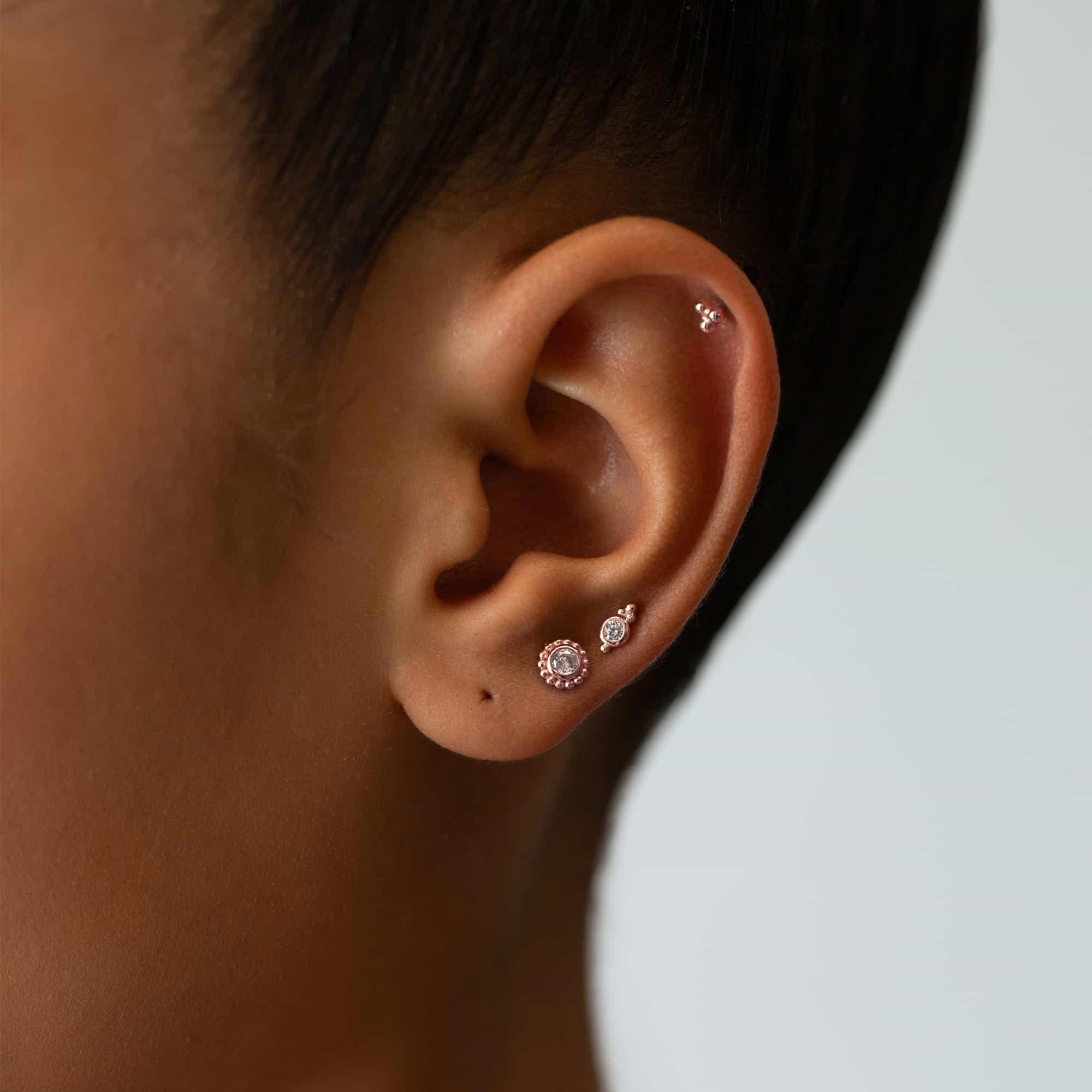 Rose gold vermeil beaded studs with white zirconia stones, styled in an ear stack on a model