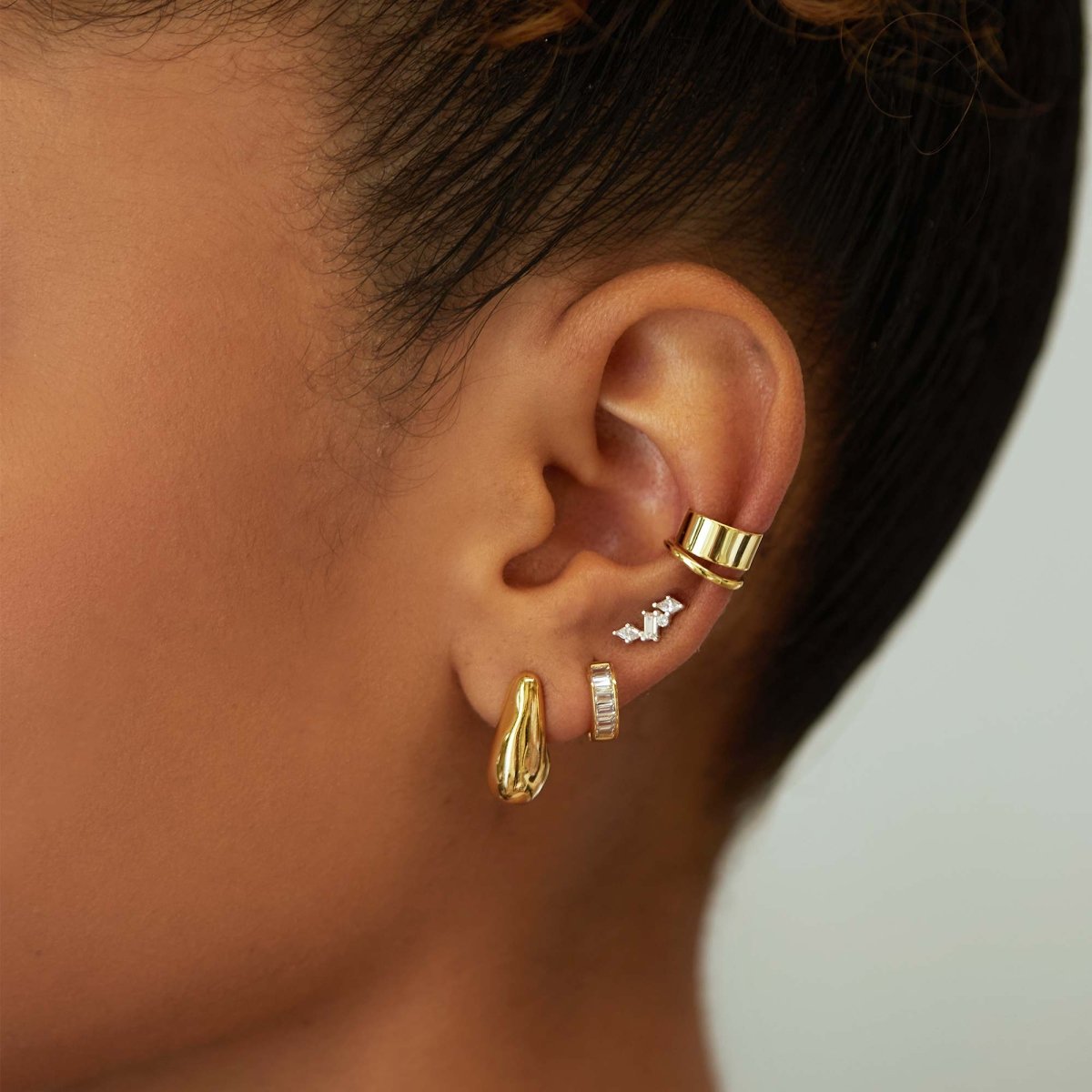 Gold vermeil scattered cluster studs with white zirconia stones, shown on a model's lobe