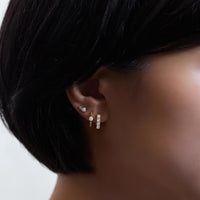 Close-up on woman's face featuring Gold Vermeil Gemstone Bead Huggies Opal and stud. 