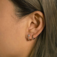 Close-up of woman's ear featuring Rose Gold Clover Pave Huggie Earrings and gold huggie. 