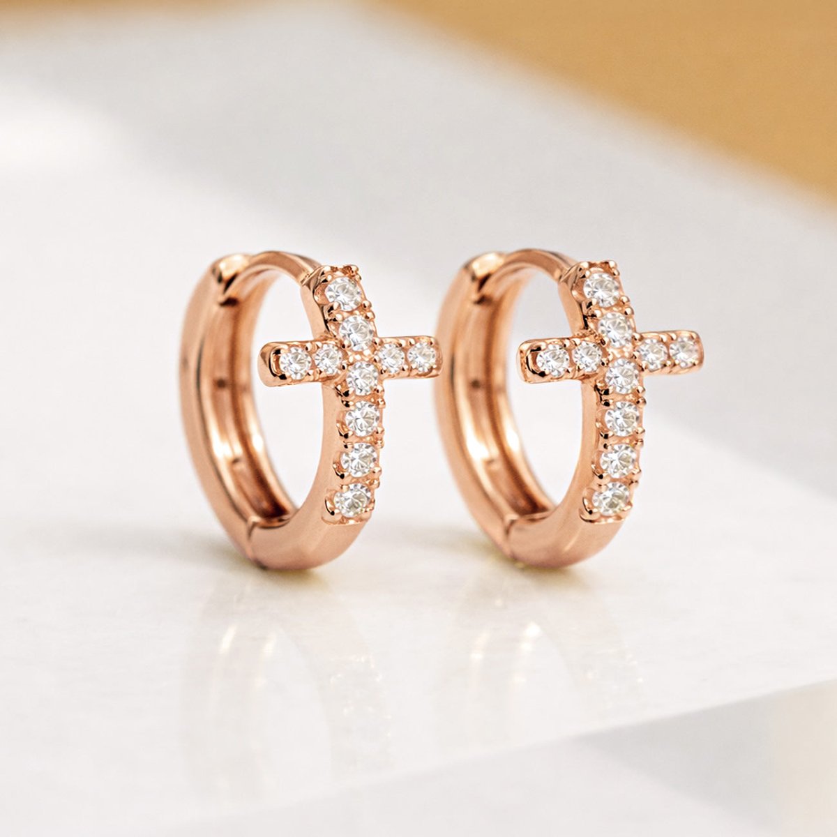 Rose Gold Cross Huggie Earrings featuring pavé cubic zirconia crystals from AMYO.