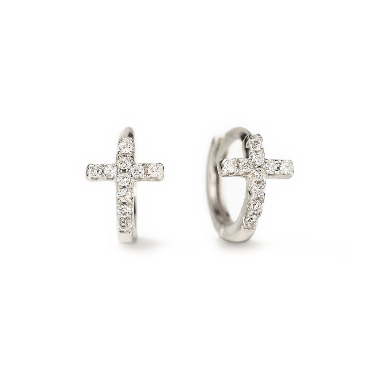 A pair of silver huggie earrings in the shape of a cross, each adorned with sparkling cubic zirconia stones.