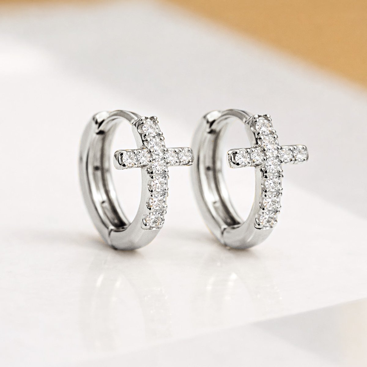 Sterling Silver huggie hoop earrings with cross designs and Rose Gold Cross Huggie Earrings pavé cubic zirconia crystals from AMYO.