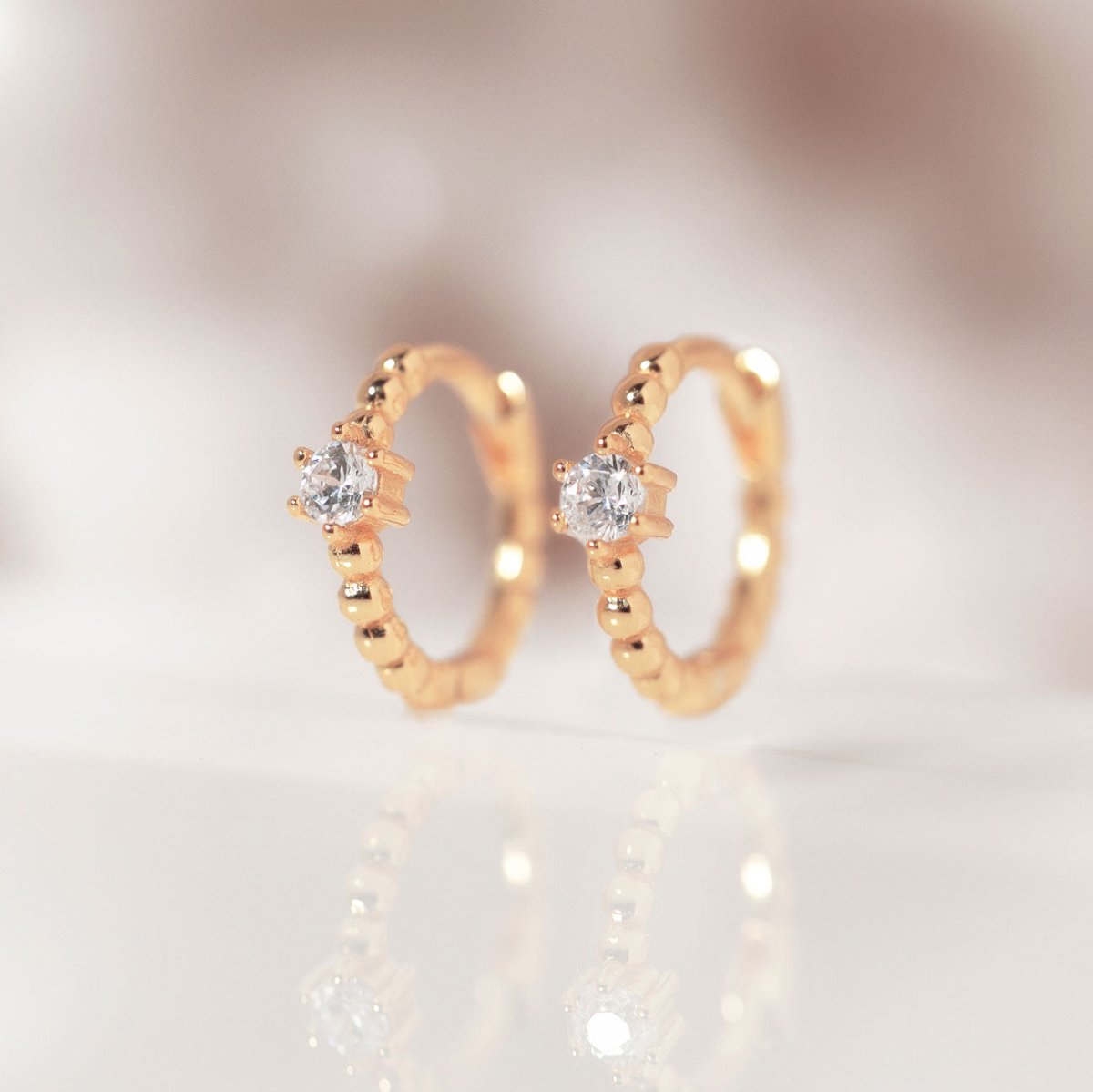 Close-up on earring featuring Rose Gold Pave Bead Huggie Earrings CZ Crystal 