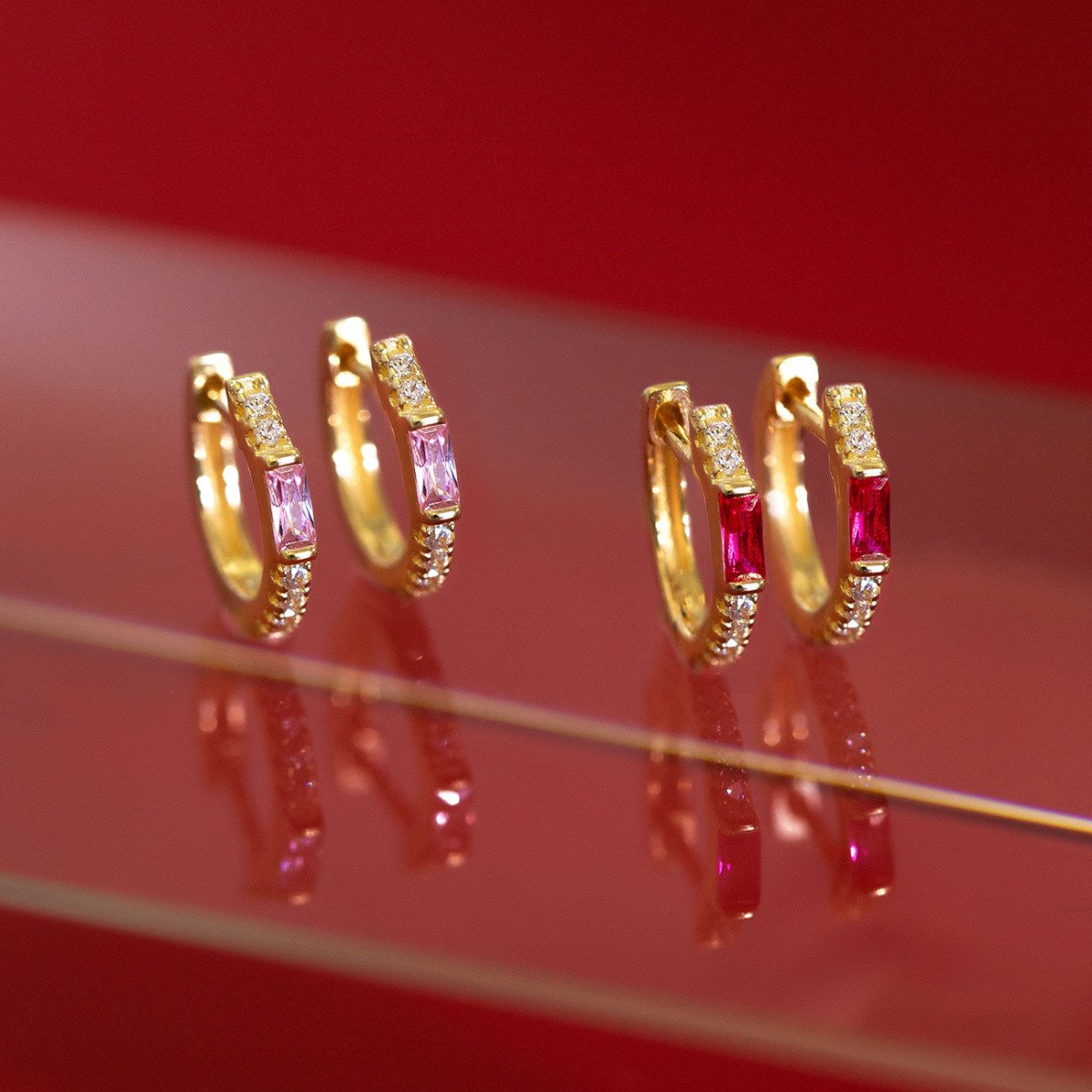 Close-up on earrings featuring Gold Vermeil Gemstone Baguette Huggie Earrings Ruby + Pink 