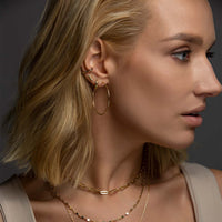 Side profile of woman's face featuring Gold Vermeil Thin Large Hoops and other dainty earrings. 