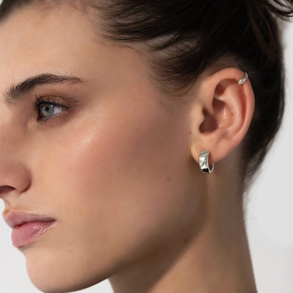 Close-up of woman's ear featuring AMYO's Chunky Boyfriend Mini Hoops in Sterling Silver