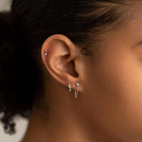 Close-up of woman's ear featuring 14K White Gold Tiny Sapphire paired ewith crescent moon and star stud earring 