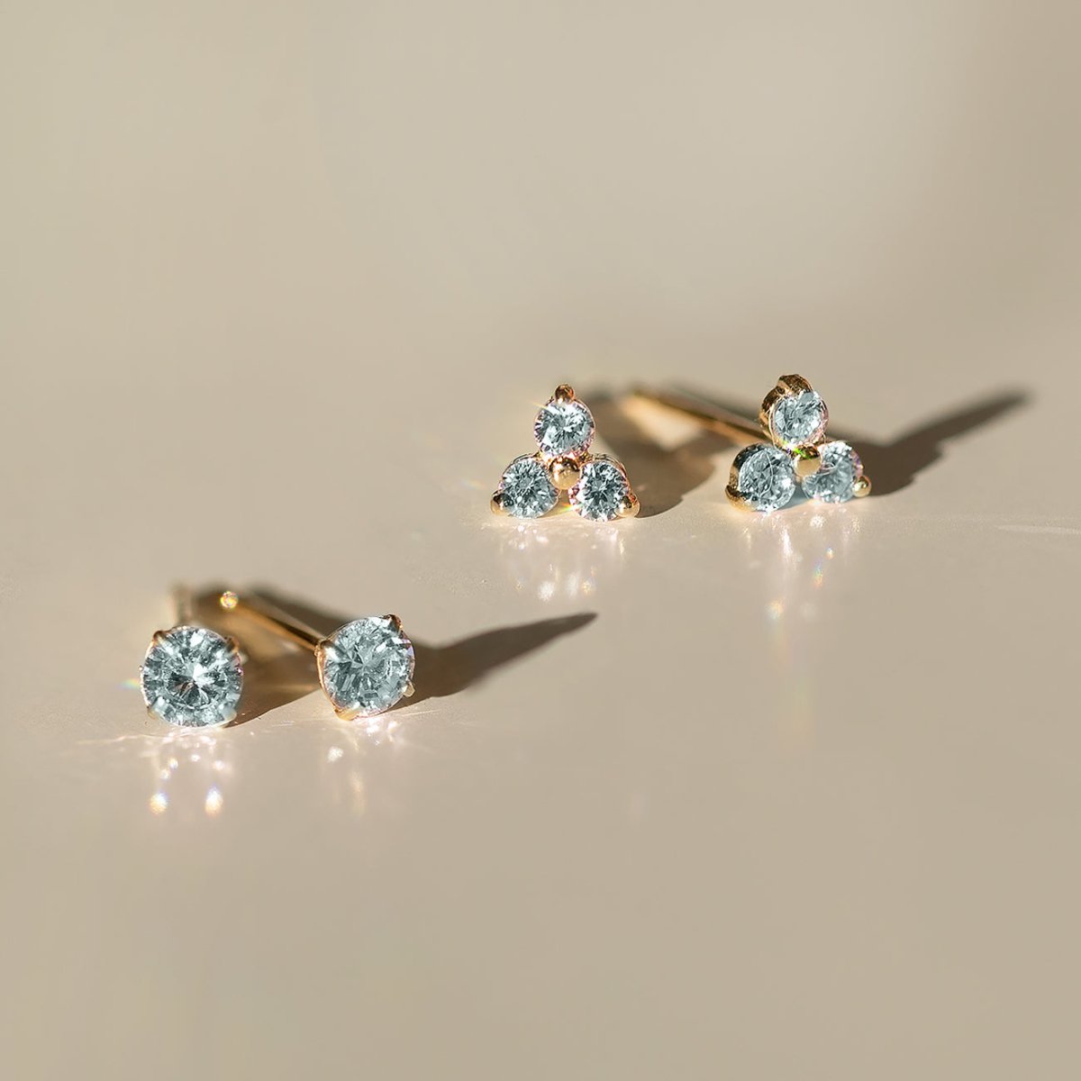 Close up of earring featuring 14K Gold Gemstone Clover Studs Aquamarine CZ Crystal 