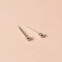 Close-up of earrings featuring Tiny 14K White Gold Sphere Studs