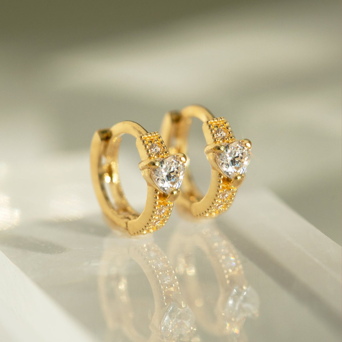 Close up of earring featuring Gold Vermeil Tiny Heart Huggies