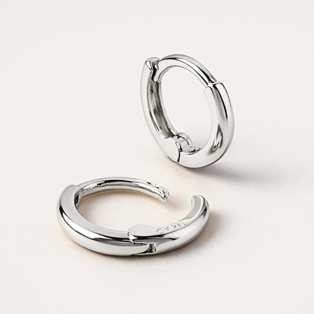 Close up shot of AMYO'S 14K White Gold Mini Huggie Hoops