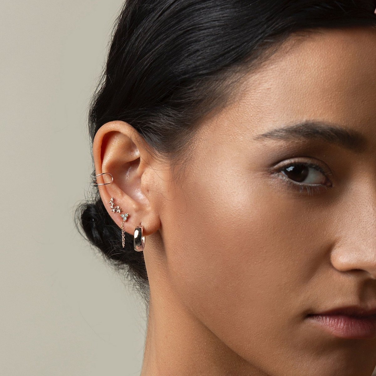 14K white gold star cluster stud styled in an ear stack with a hoop, on a model