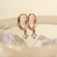 Close-up of earring featuring 14K Rose Gold Pavé Dangle Huggie Earrings