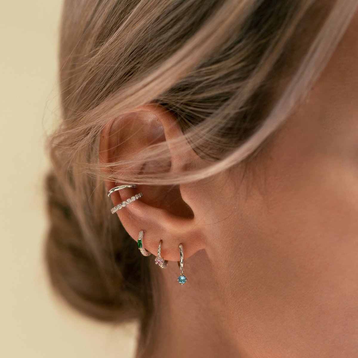 Close-up of woman's ear featuring 14K White Gold Gemstone Dangle Huggies Aquamarine Cubic Zirconia