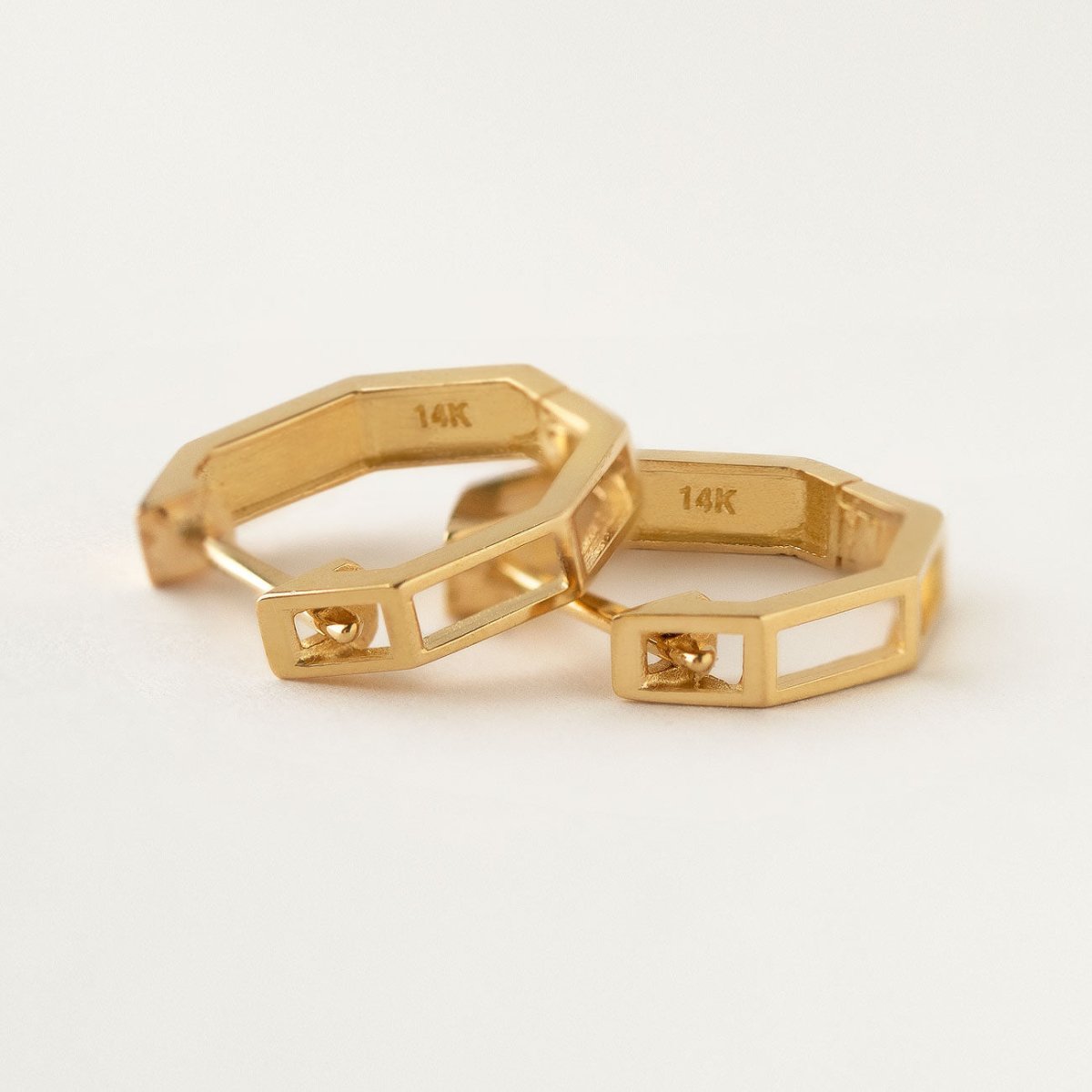 Close-up of earrings featuring 14K Solid Gold Octagon Huggie Earrings