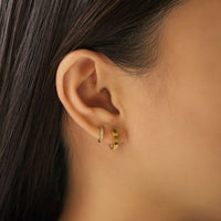 Close-up of woman's ear featuring 14K Solid Gold Octagon Huggie Earrings paired with tiny diamond huggie 