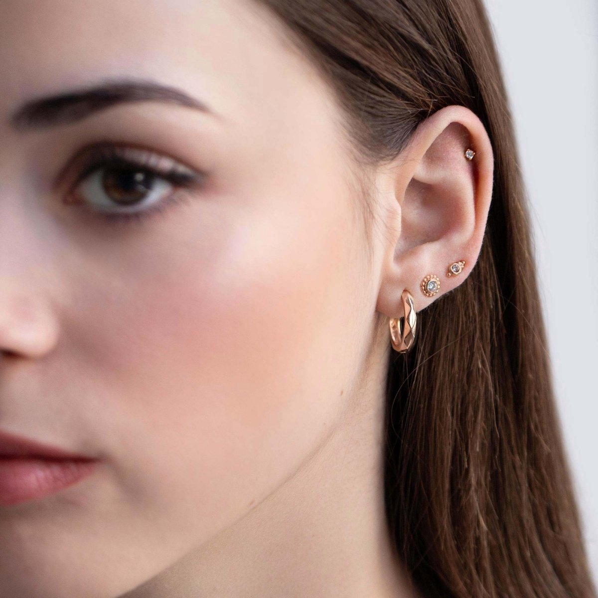 Rose gold vermeil beaded white zirconia studs shown with a hoop in an ear stack on a model
