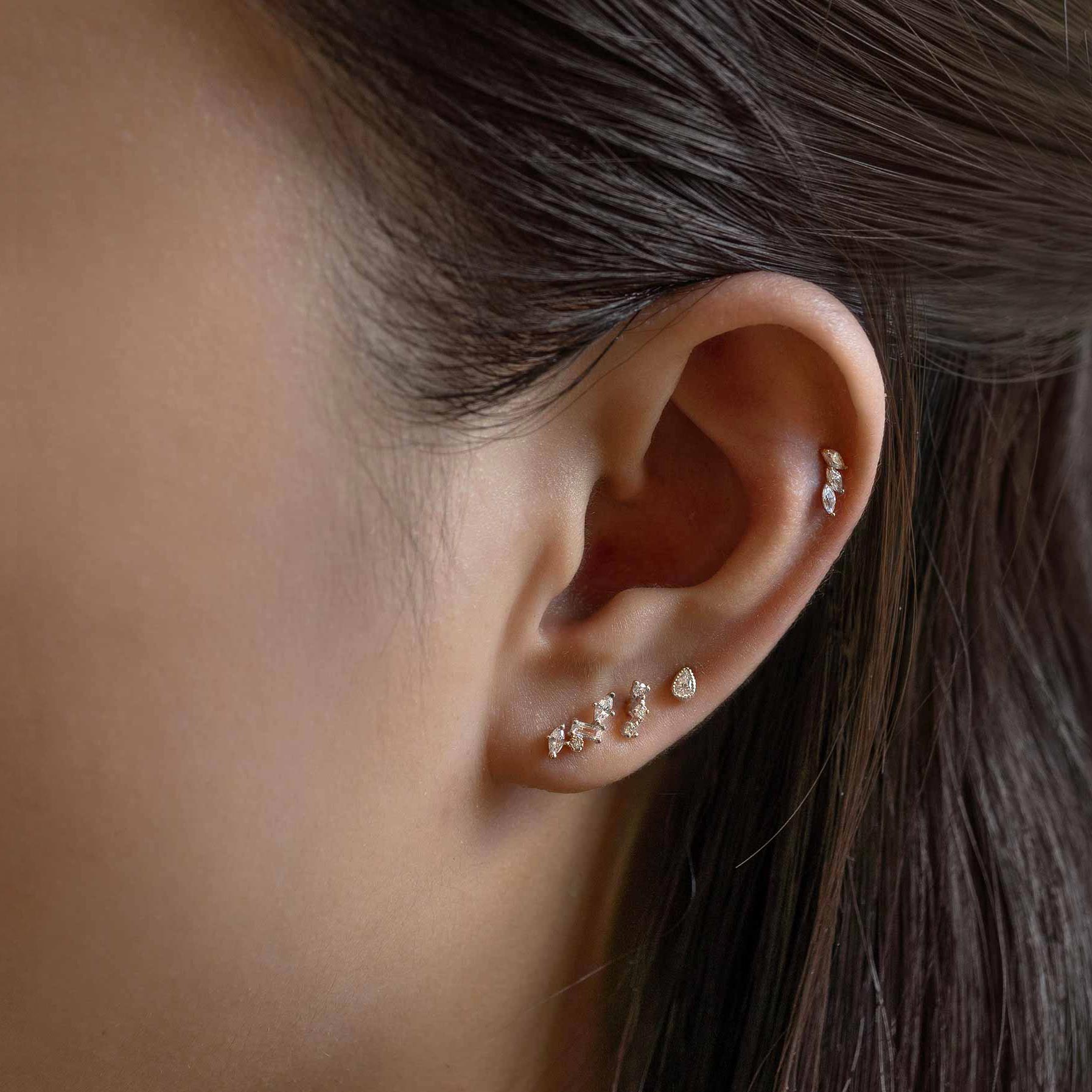 Sterling silver cluster studs with white zirconia, styled in an ear stack on a model