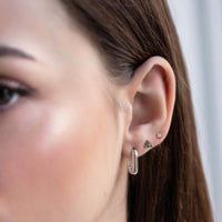 Close up of woman's ear featuring Sterling Silver Birthstone Studs Set Emerald and chunky rectangular earring 