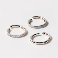 Close-up of 14k white gold cartilage pave hoop earring and stainless steel seamless clicker ring