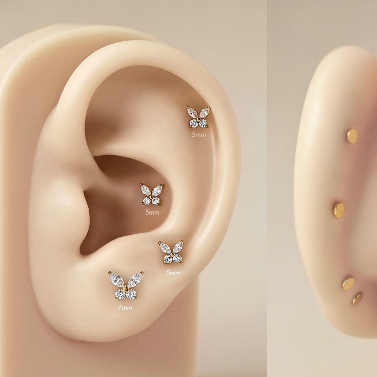 As worn photo of AMYO's Gold Titanium Crystal Butterfly Flatback Stud in 7mm and 5mm on beige silicone ear.