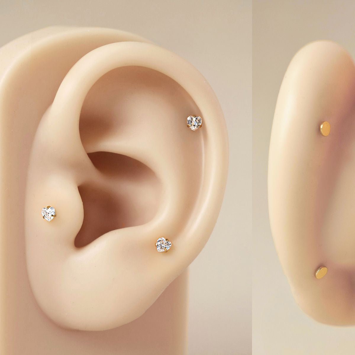 Silicone ear model showing placements of AMYO's Tiny Heart Crystal Flat Back Studs on the upper lobe and cartilage, serving as a size and styling guide. 