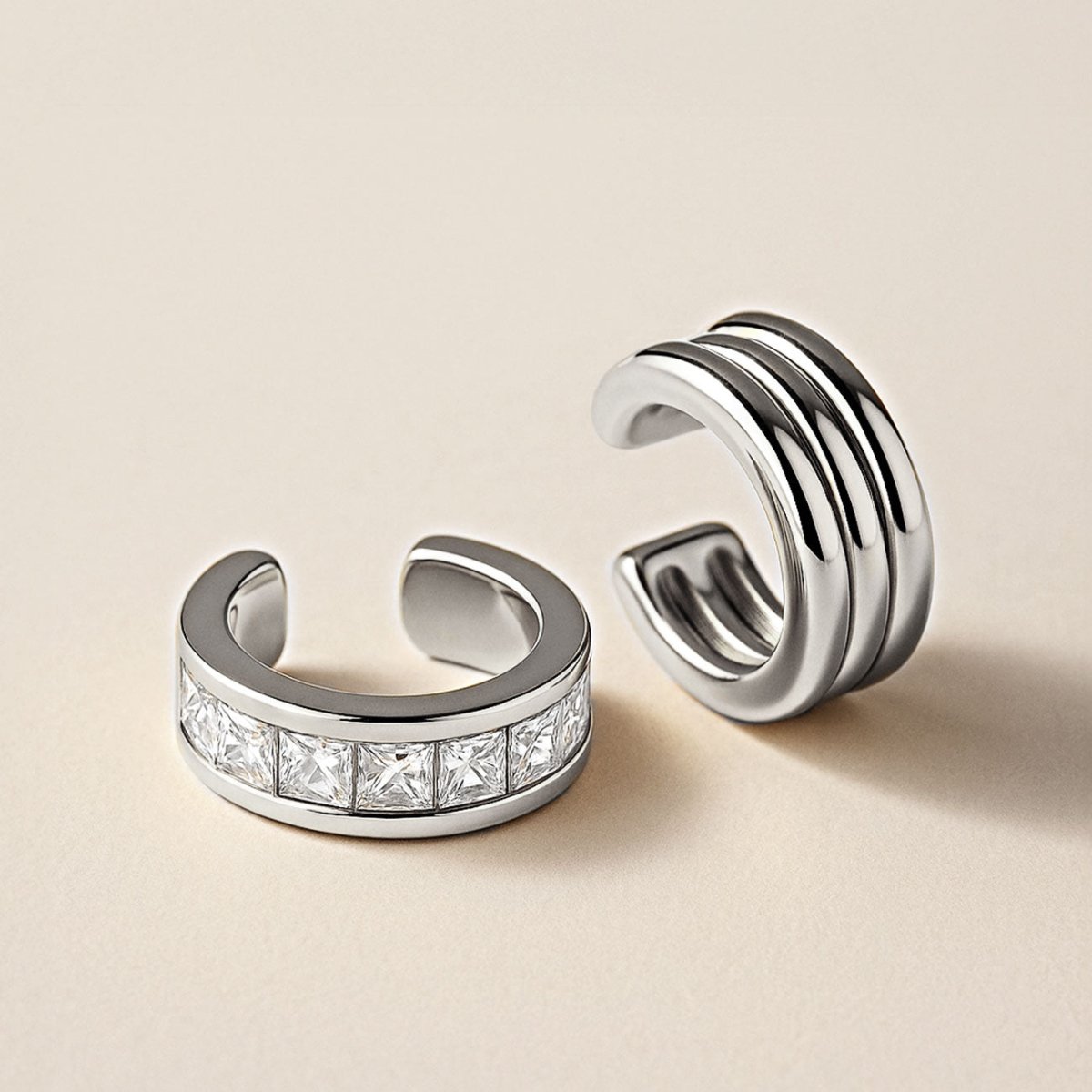 Bold Silver ear cuffs on a beige background from AMYO. 