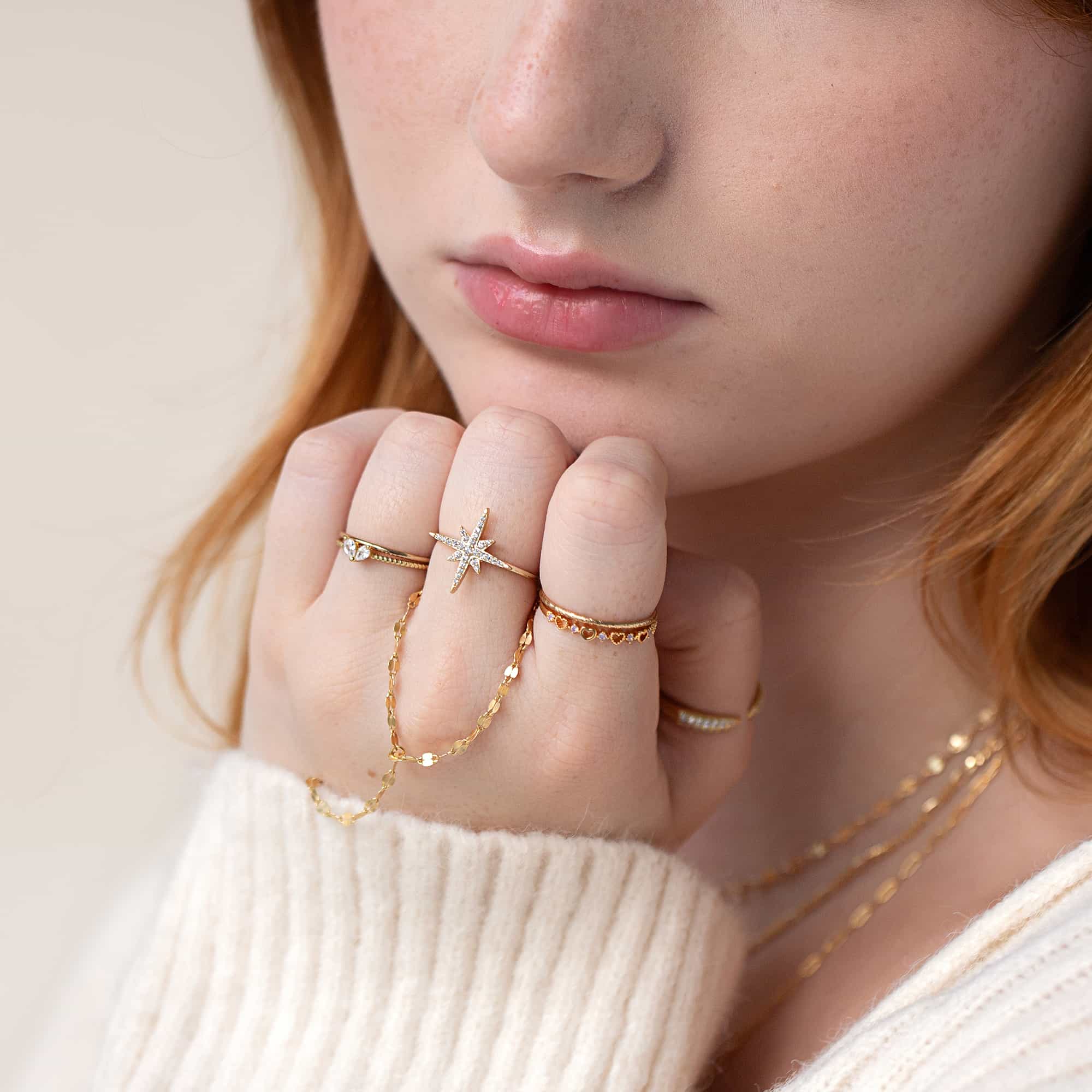 Gold vermeil heart stacking ring with white zirconia, shown stacked on a model's finger