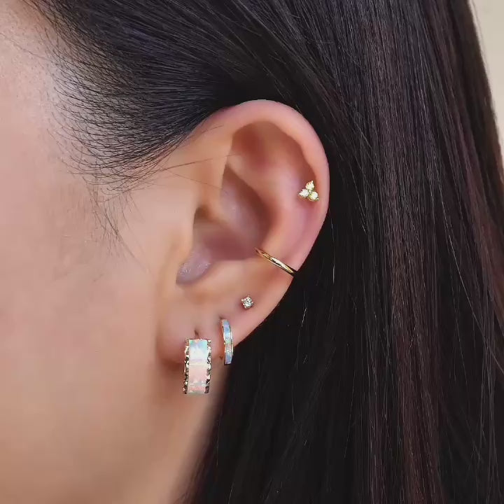 model wearing 14k gold opal earrings, conch cartilage hoop and flat back studs from AMYO.